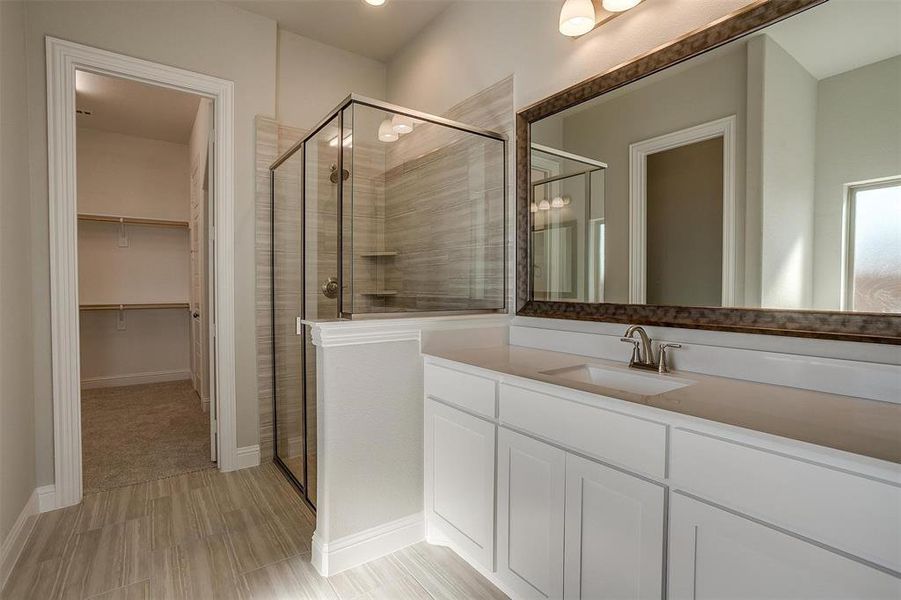 Bathroom with vanity and a shower with door