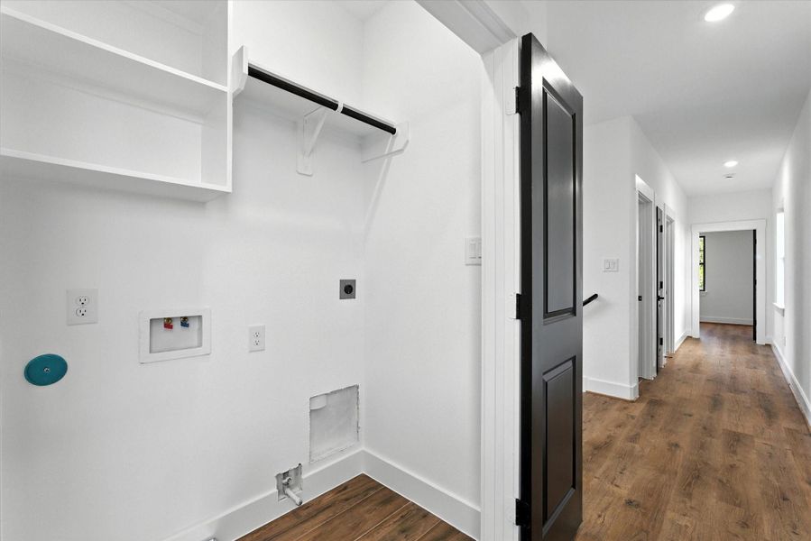 Convenient private laundry area with gas and electric dryer connections, built-in shelving for storage, and a hanging rod for added functionality.