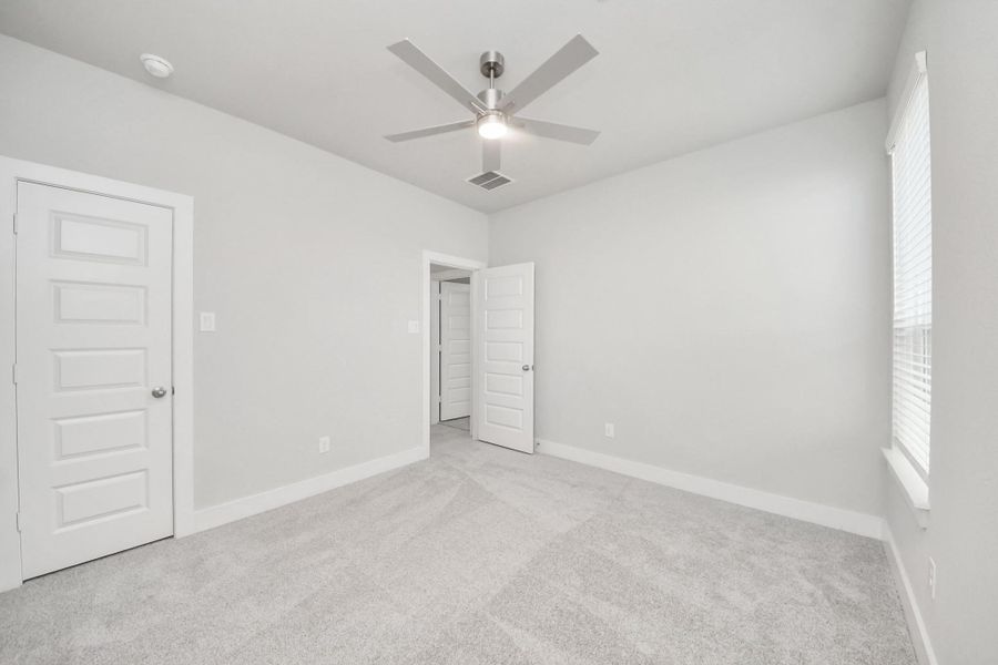 Generously sized secondary bedrooms featuring spacious closets, soft and inviting carpeting underfoot, large windows allowing plenty of natural light, and the added touch of privacy blinds for your personal retreat. Sample photo of completed home with similar floor plan. Actual colors and selections may vary.