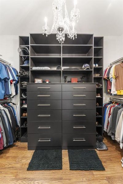 Spacious closet featuring light wood-type flooring and a chandelier
