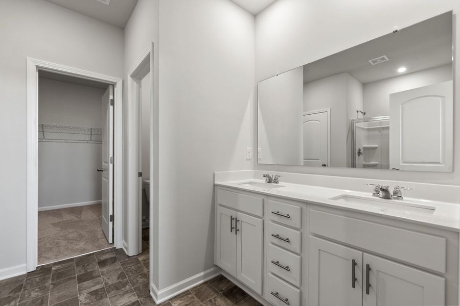 A bathroom with white cabinets.