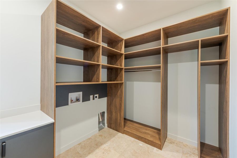 Custom shelving and hanging space define this highly organized laundry area.