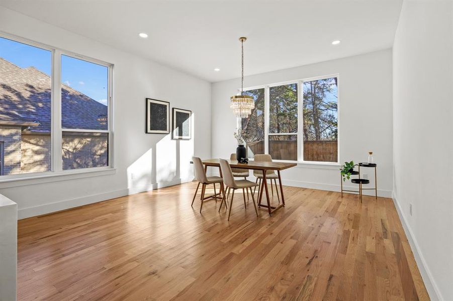 Dining space featuring a chandelier, light wood-type flooring, and plenty of natural light