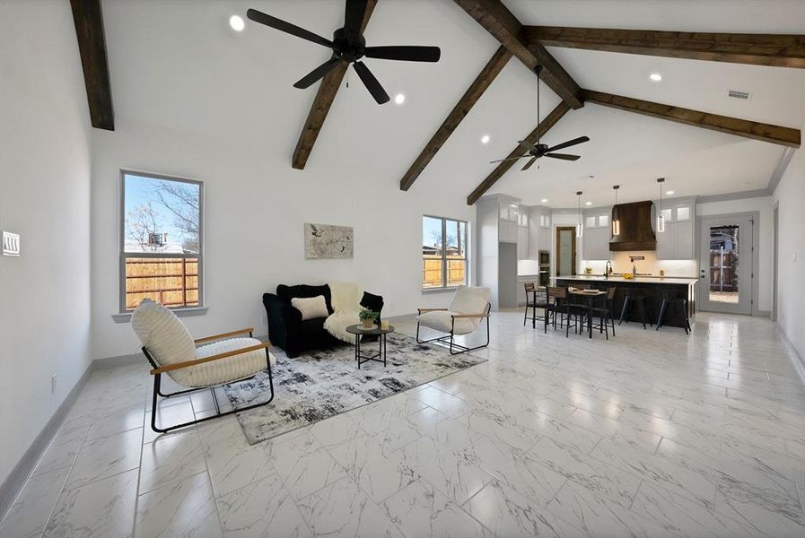 Living room with light marble finish floors, high vaulted ceiling, recessed lighting, and beamed ceiling