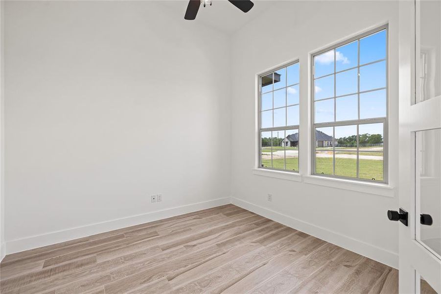 Unfurnished room featuring light wood-type flooring and a ceiling fan Unfurnished room featuring light wood-type flooring and a ceiling fan