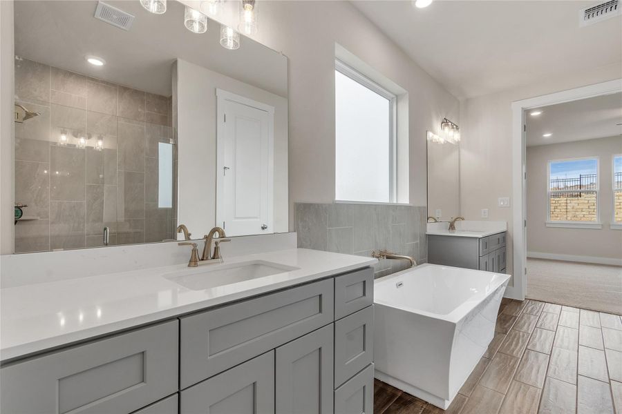 A well-appointed primary bath with a standalone tub and separate shower offers a private sanctuary.