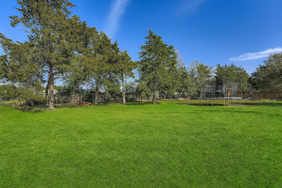 View of green lawn featuring a trampoline View of green lawn featuring a trampoline