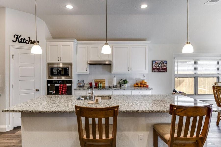 Experience the elegance of this kitchen, boasting sleek stainless steel appliances, a convenient walk-in pantry, and stylish modern white cabinets that create a perfect blend of functionality and beauty.