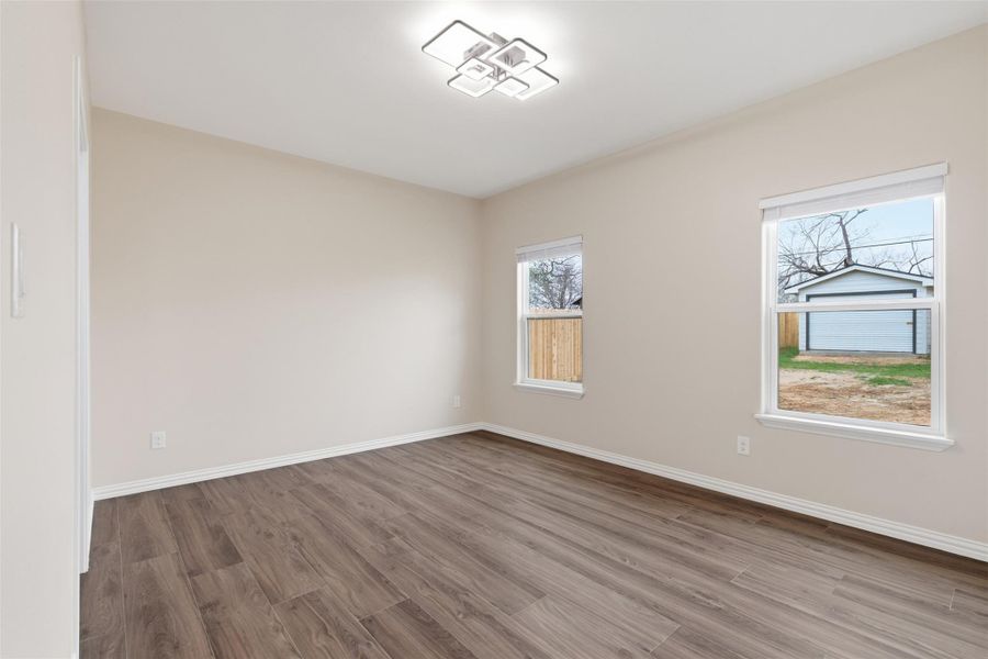 Unfurnished room with wood finished floors and baseboards