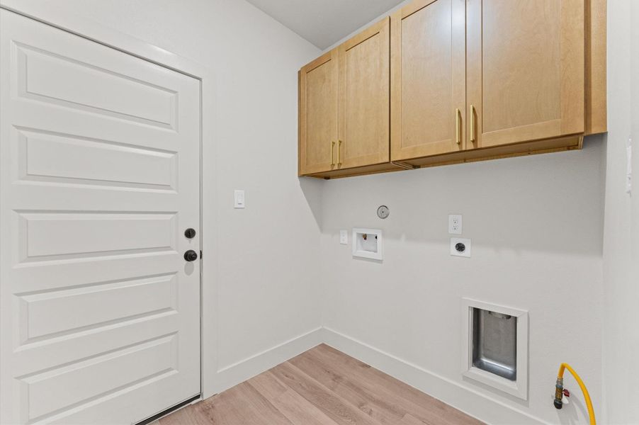 The laundry room includes matching cabinetry to the home and both electric & gas dryer connections.