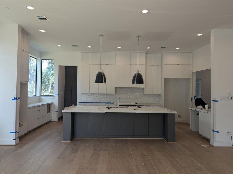 Kitchen with island and entry to pantry at the rear.