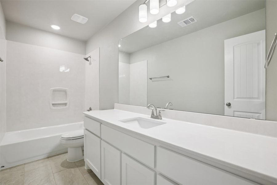 Bathroom featuring vanity,  shower combination, and light tile patterned floors