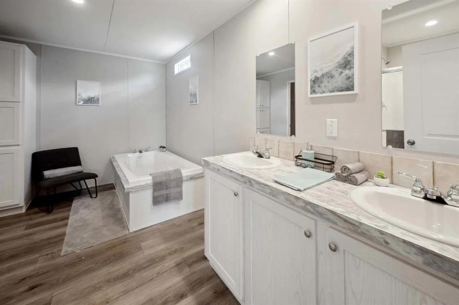 Bathroom featuring a washtub, vanity, and hardwood / wood-style flooring