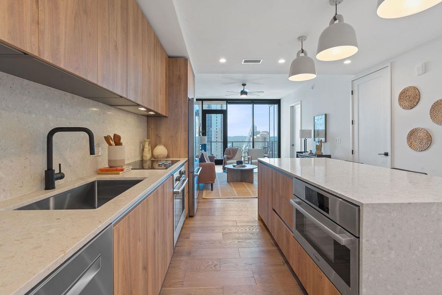 Representative Photo. Kitchen featuring custom Italkraft cabninetry, terrazzo backsplash, waterfall-edge terrazzo countertops, stainless steel Bosch appliances, and pendant lighting above kitchen island