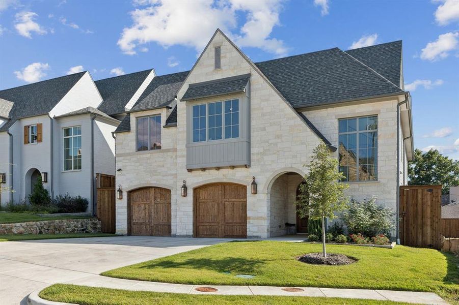 French provincial home with stone siding, roof with shingles, driveway, and an attached garage French provincial home with stone siding, roof with shingles, driveway, and an attached garage