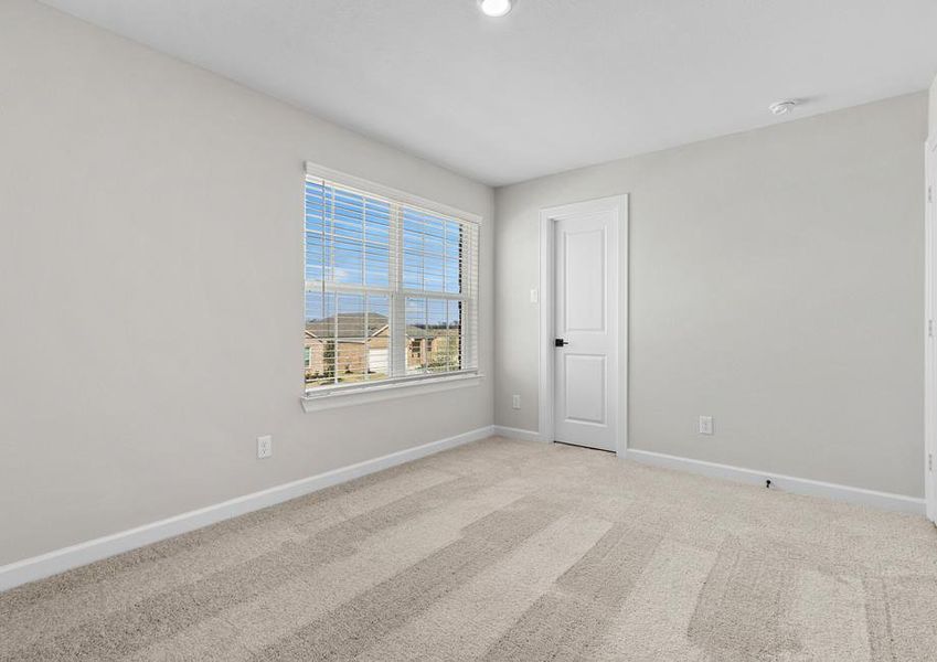 Windows let in plenty of light to this secondary bedroom.