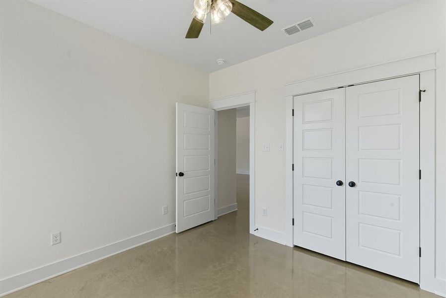 Unfurnished bedroom with concrete flooring, a closet, and ceiling fan