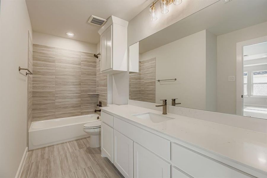 Bathroom featuring vanity, bathtub / shower combination, and recessed lighting