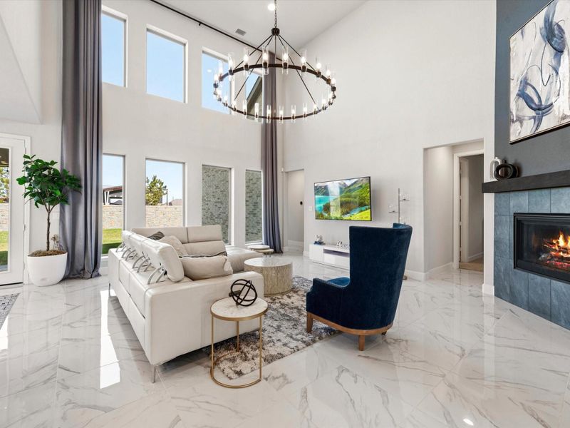 Two story high ceiling with an amazing chandelier to illuminate the den. A wall of windows with gleaming marble-look large format tile floors that flow throughout the common areas of the first floor.