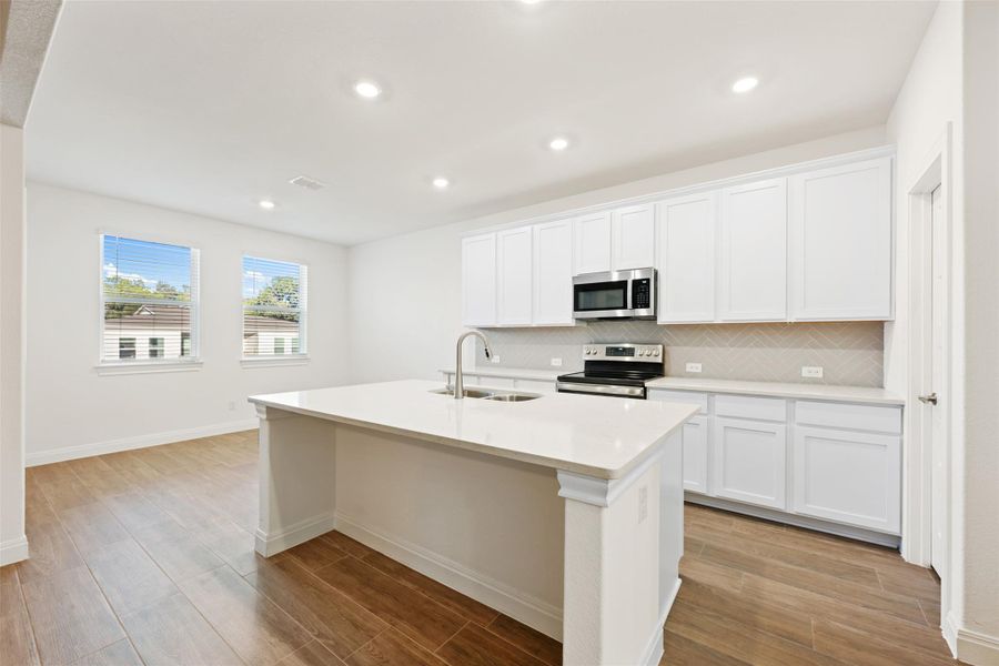 Kitchen with white cabinetry, light wood-type flooring, stainless steel appliances, tasteful backsplash, and recessed lighting Kitchen with white cabinetry, light wood-type flooring, stainless steel appliances, tasteful backsplash, and recessed lighting
