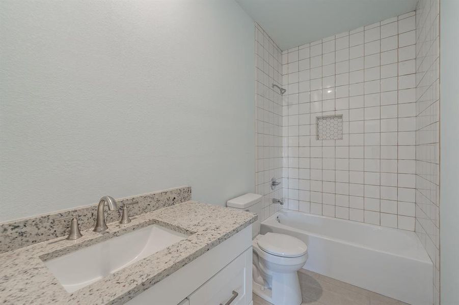 Full bath featuring vanity, bathing tub / shower combination, and tile patterned floors Full bath featuring vanity, bathing tub / shower combination, and tile patterned floors