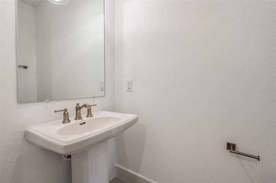 Bathroom featuring a textured wall and a sink Bathroom featuring a textured wall and a sink