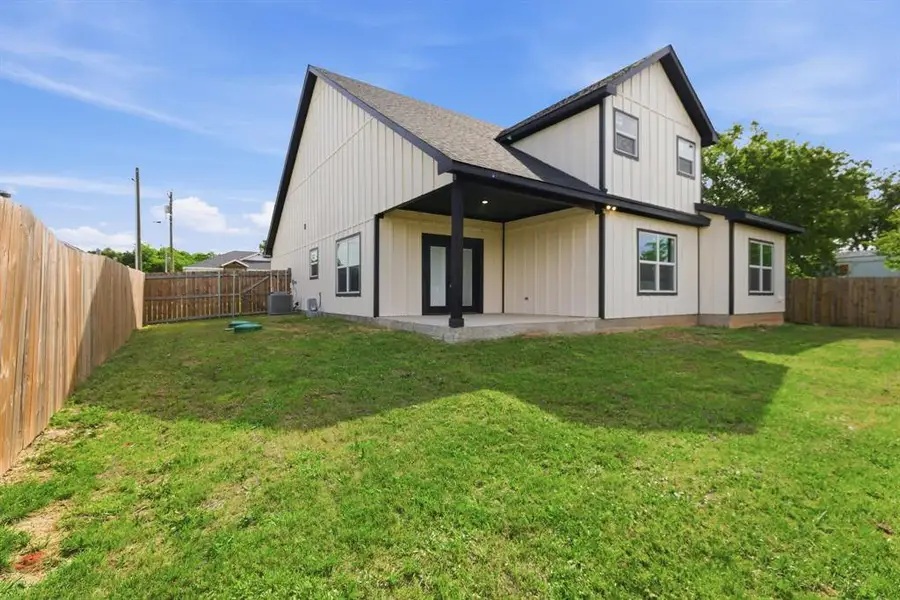 Rear view of house featuring board and batten siding, a patio area, a fenced backyard, and a shingled roof Rear view of house featuring board and batten siding, a patio area, a fenced backyard, and a shingled roof