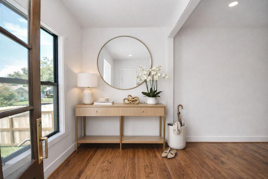 After you walk through the main door. You walk into a refined entry foyer featuring wide-plank hardwood floors, clean architectural lines, and natural light that creates a polished, high-end first impression