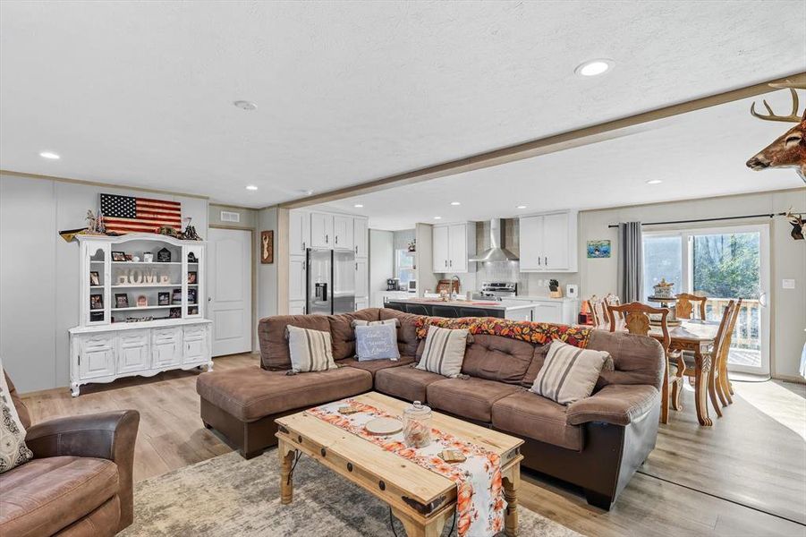 Living area with light wood-type flooring and recessed lighting Living area with light wood-type flooring and recessed lighting