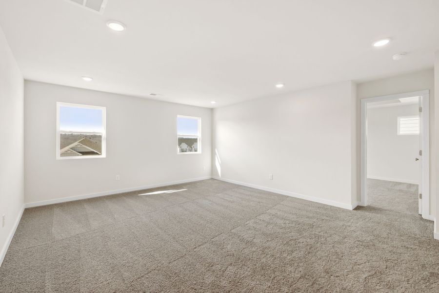 A room with a carpet and a door.