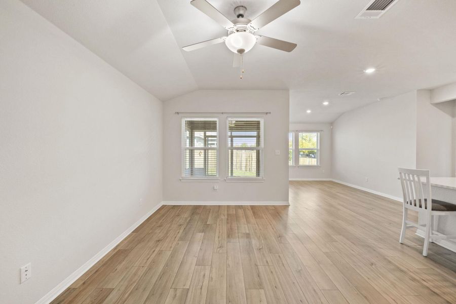 Unfurnished living room featuring light wood-type flooring, vaulted ceiling, a ceiling fan, and recessed lighting Unfurnished living room featuring light wood-type flooring, vaulted ceiling, a ceiling fan, and recessed lighting