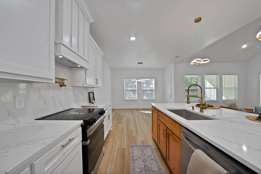 Kitchen featuring range with electric stovetop, white cabinets, brown cabinetry, light wood finished floors, and recessed lighting