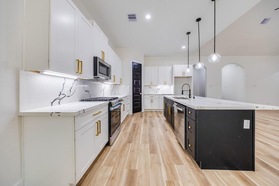 Modern open-concept kitchen with spacious layout, sleek finishes, and seamless flow into the living and dining areas.