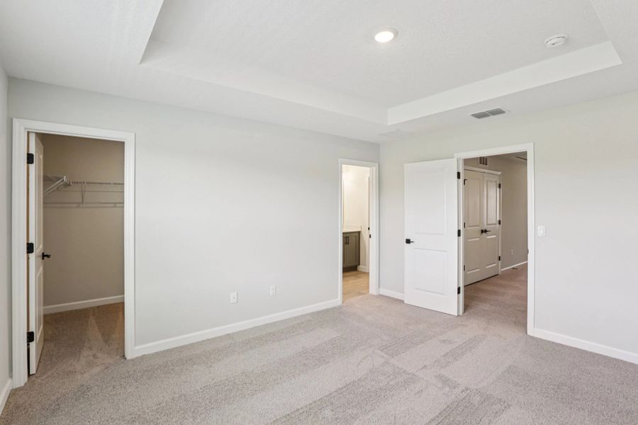 Primary bedroom features a large walk-in closet and spacious primary bathroom -  Representative images and renderings are for illustrative purposes