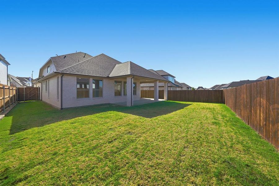 Rear view of property with brick siding, a patio area, a shingled roof, and a fenced backyard Rear view of property with brick siding, a patio area, a shingled roof, and a fenced backyard