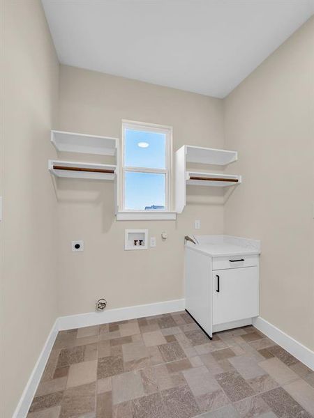 Clothes washing area with hookup for a washing machine, cabinets, hookup for an electric dryer, and hookup for a gas dryer