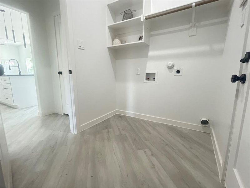 Clothes washing area featuring gas dryer hookup, hookup for an electric dryer, light wood-type flooring, and washer hookup