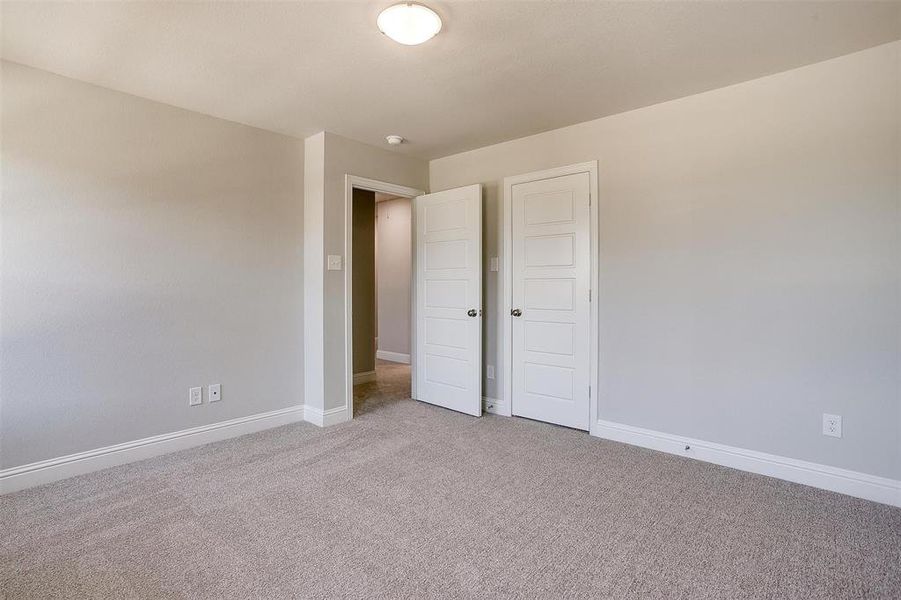 Unfurnished bedroom featuring light carpet and baseboards Unfurnished bedroom featuring light carpet and baseboards