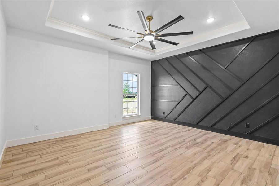Unfurnished room featuring a decorative wall, light wood-style flooring, a ceiling fan, and recessed lighting