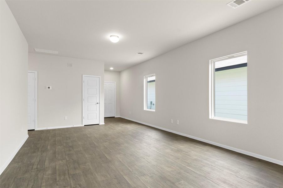 Empty room featuring dark wood-type flooring and baseboards Empty room featuring dark wood-type flooring and baseboards