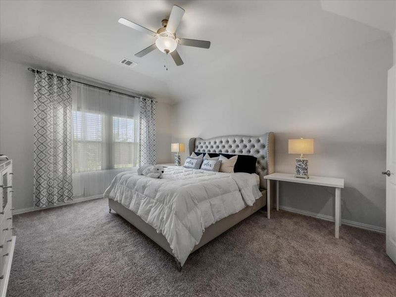 Carpeted bedroom with lofted ceiling and ceiling fan