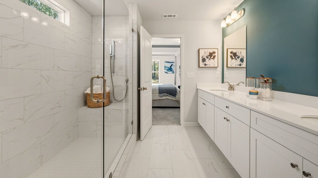 Primary bathroom with dual vanity and spacious glass enclosed shower with shower window Primary bathroom with dual vanity and spacious glass enclosed shower with shower window