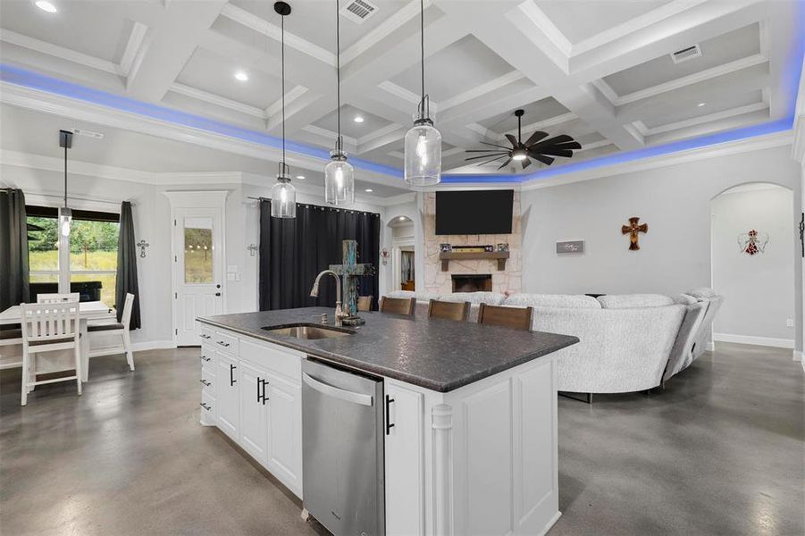 Kitchen featuring ceiling fan, sink, a center island with sink, and white cabinets