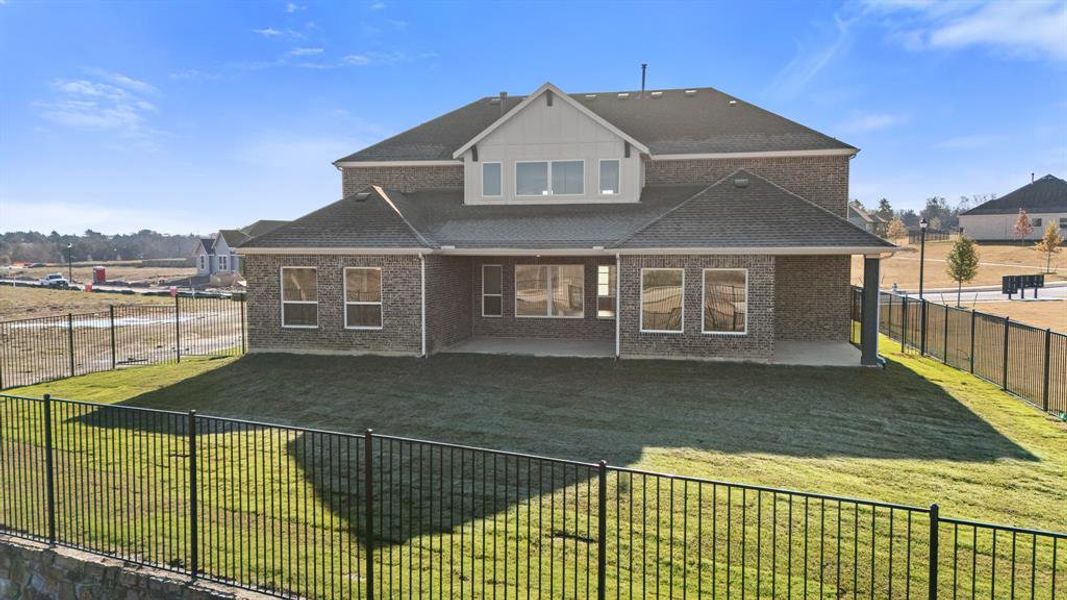 Rear view of property with a patio area, a shingled roof, and brick siding