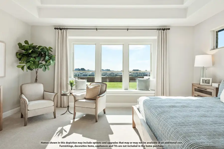 Bright master bedroom with tray ceiling, large windows, seating area, and neutral carpet flooring Bright master bedroom with tray ceiling, large windows, seating area, and neutral carpet flooring