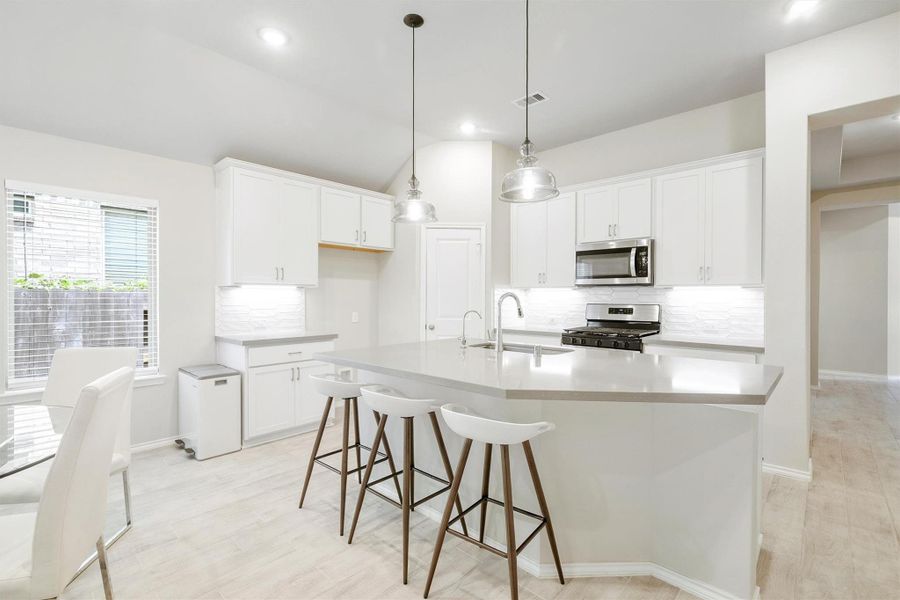 White shaker cabinets, Omega Stone countertops, a gas range, stainless steel appliances, and pendant lights over the island that make this kitchen as good-looking as it is functional. The breakfast bar seating and pantry access make it the kind of kitchen you actually want to cook in. White shaker cabinets, Omega Stone countertops, a gas range, stainless steel appliances, and pendant lights over the island that make this kitchen as good-looking as it is functional. The breakfast bar seating and pantry access make it the kind of kitchen you actually want to cook in.
