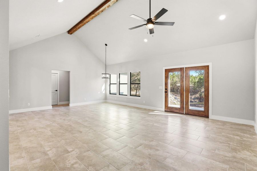 Vast interior volume enhanced by a vaulted ceiling with a rustic beam and inviting patio access. Vast interior volume enhanced by a vaulted ceiling with a rustic beam and inviting patio access.