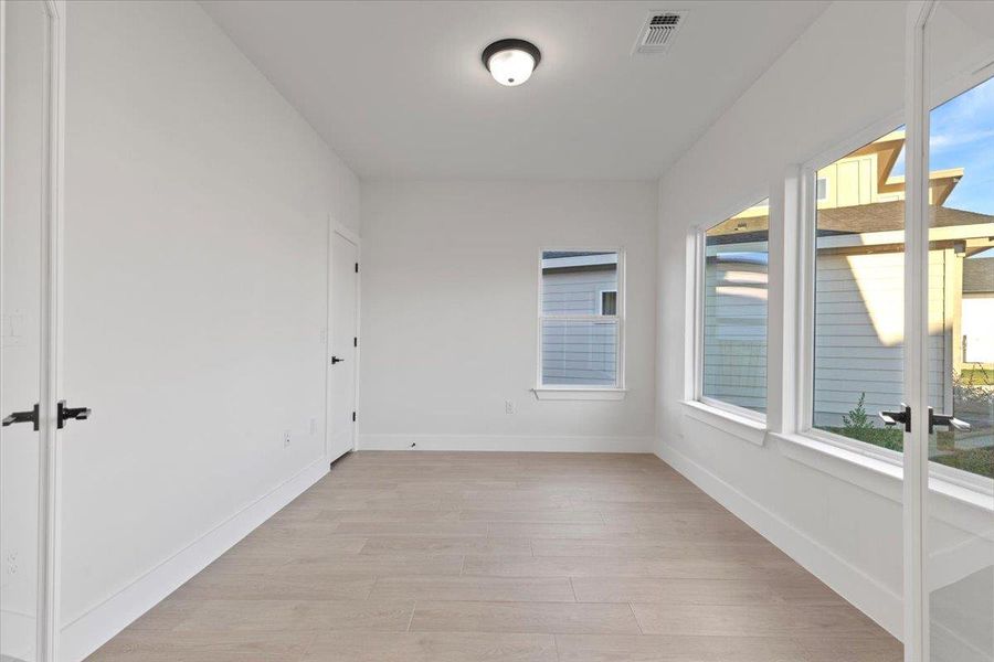 Unfurnished room with baseboards and light wood finished floors Unfurnished room with baseboards and light wood finished floors