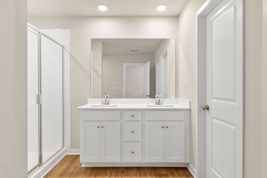 A bathroom with white cabinets.