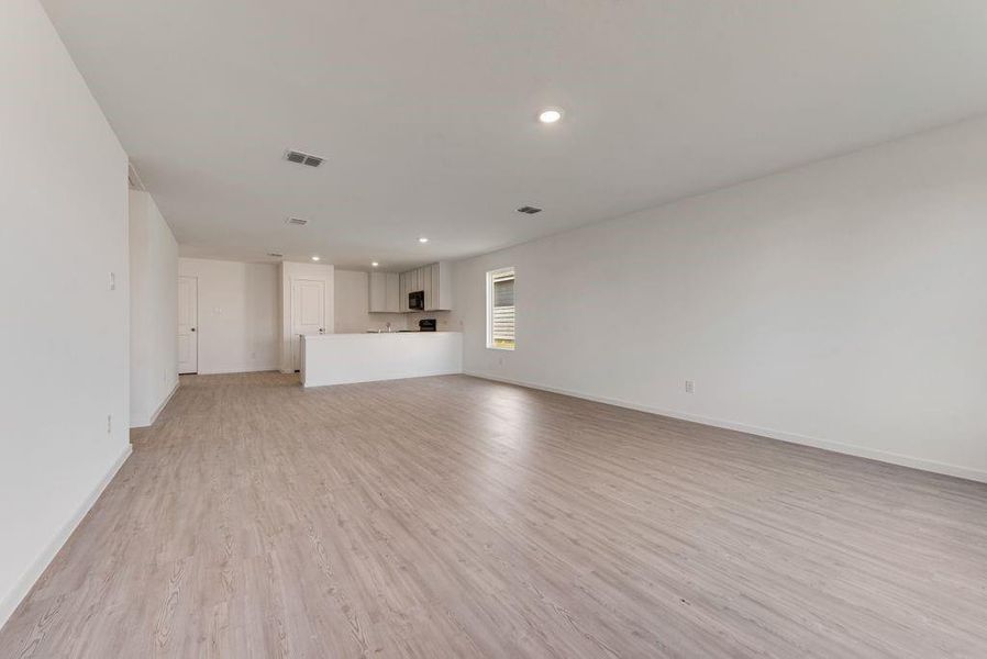 Unfurnished living room featuring light wood finished floors, recessed lighting, visible vents, and baseboards